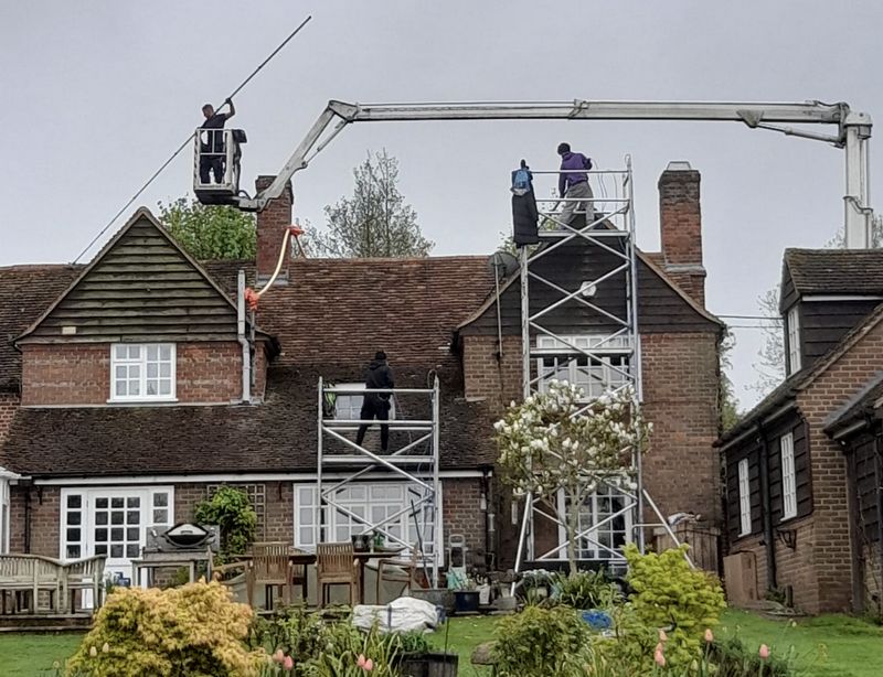 The Roof Moss Cleaners using cherry picker and scaffolding to clean roof safely and professionally in Horley, Surrey
